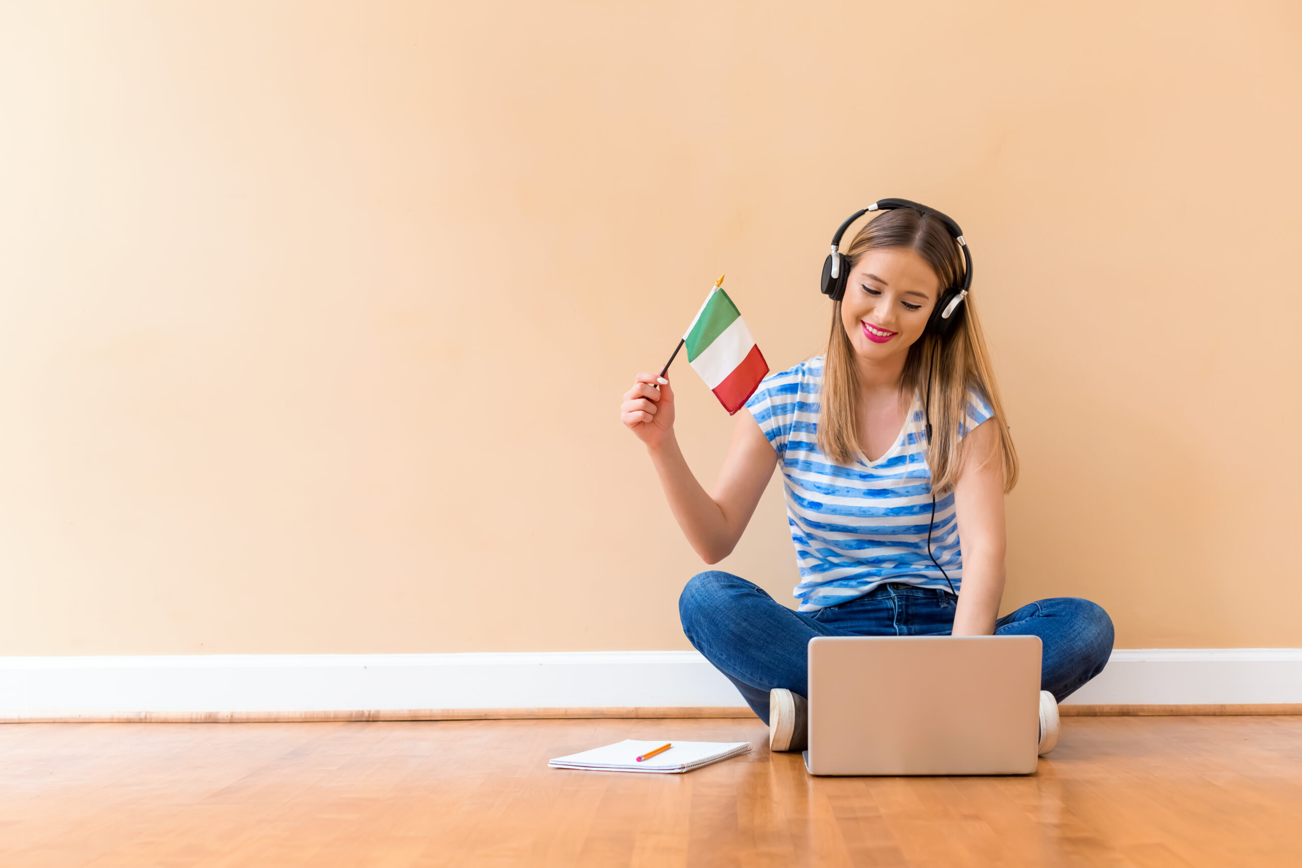 Young woman with Italian flag using a laptop computer